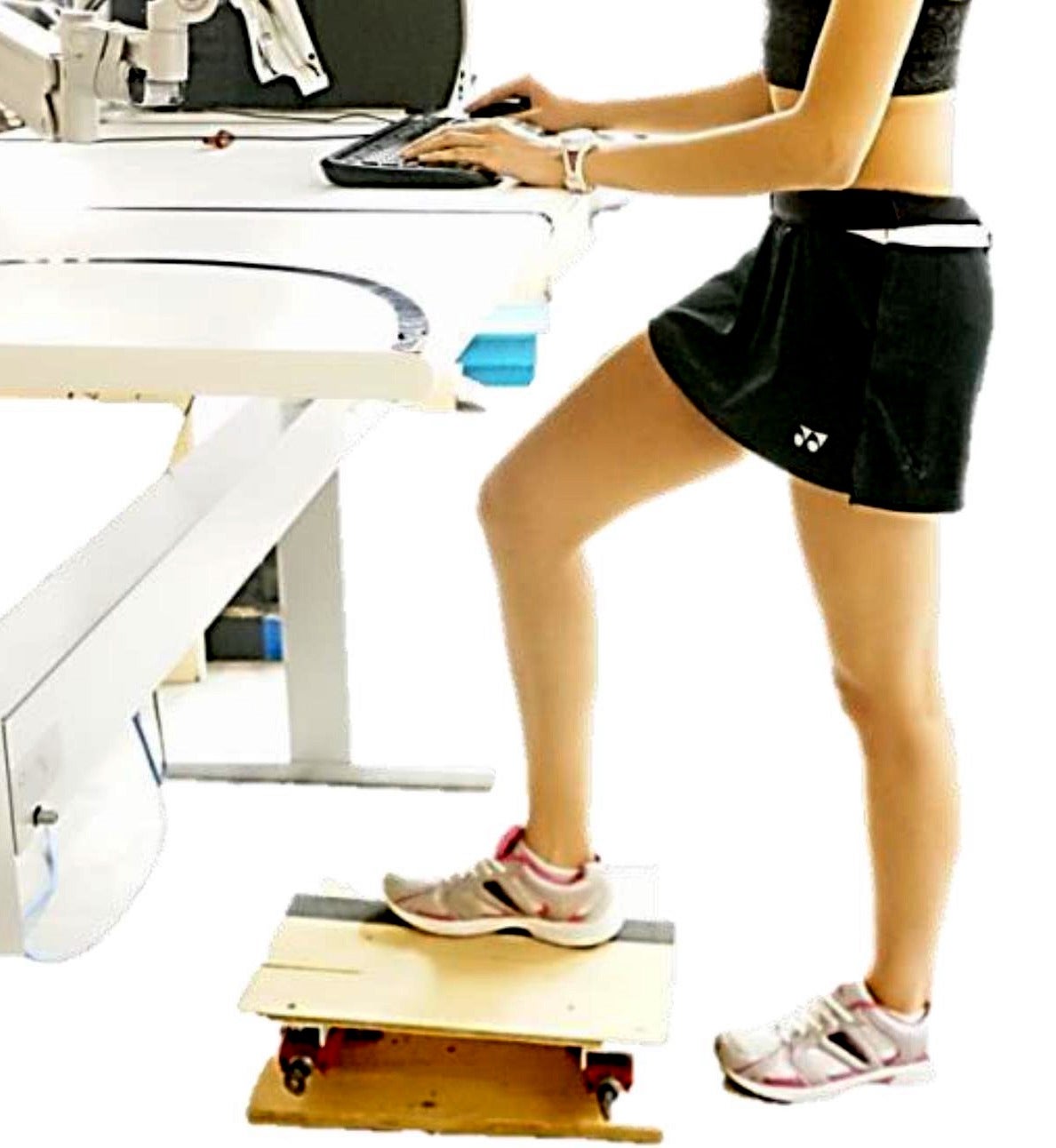 Woman at standing desk with foot on footrest