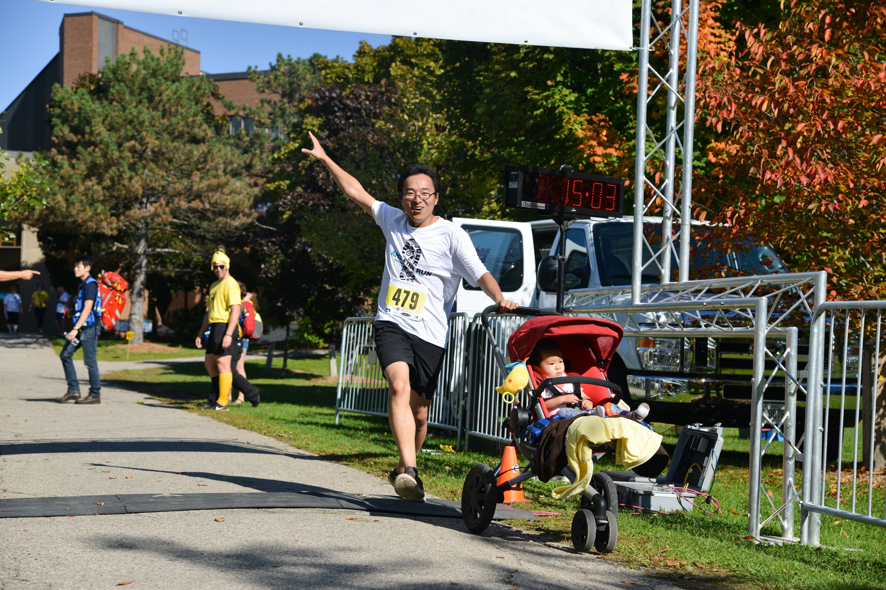 Participant pushing stroller passing the finish line