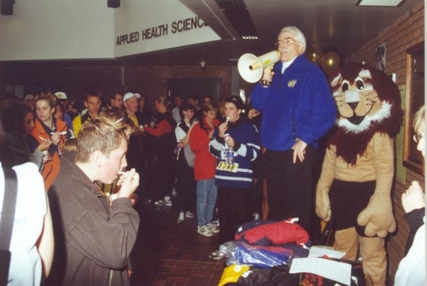 A man with a megaphone talking to a crowd 