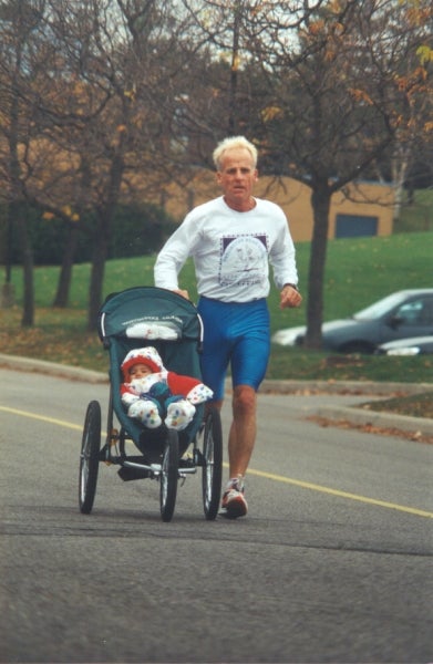 A man running with baby in a baby stroller