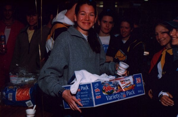 Female holding a box filled with snacks and bringing it to the crowd