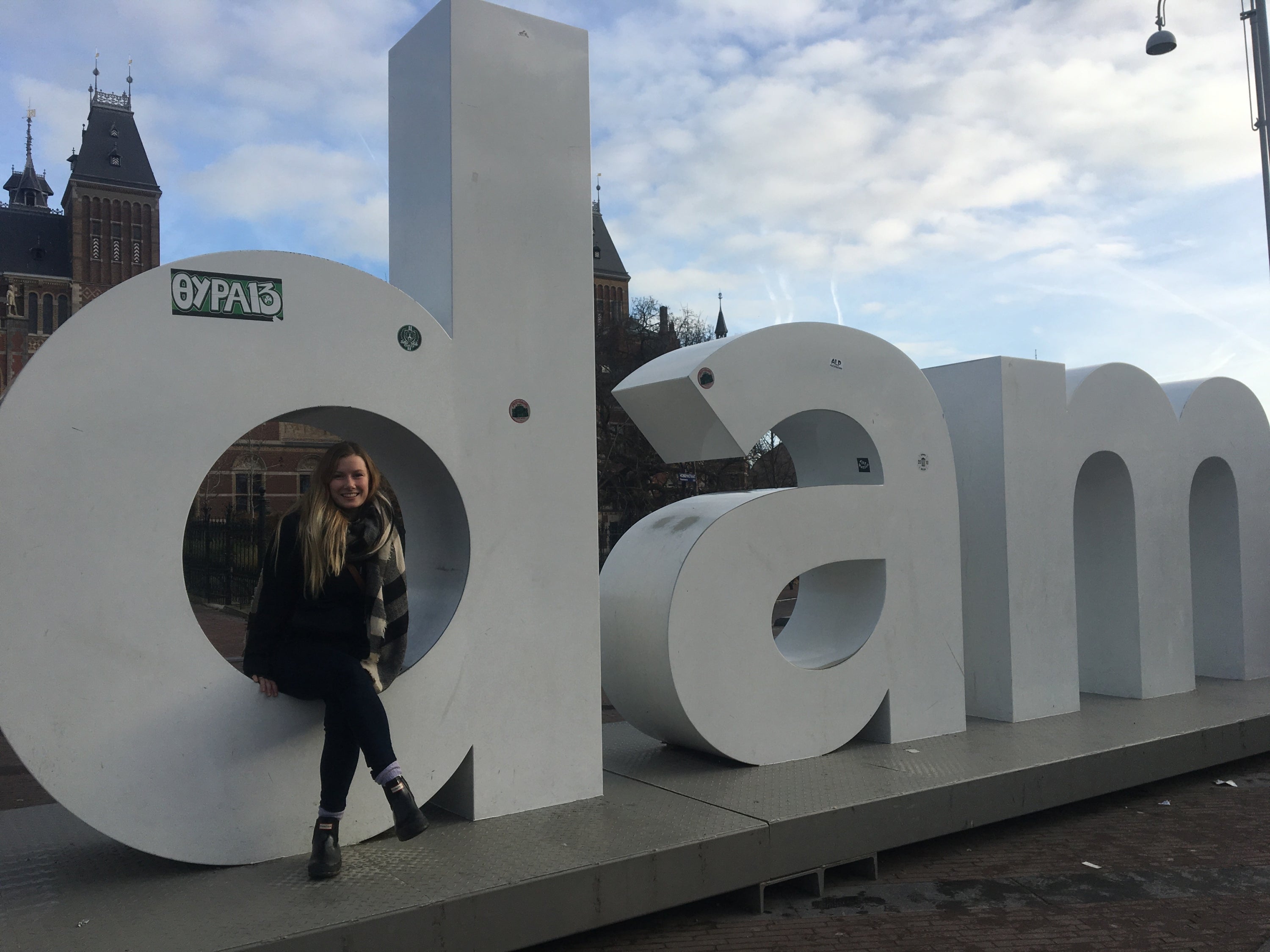 Tess sitting on the I am Amsterdam sign 