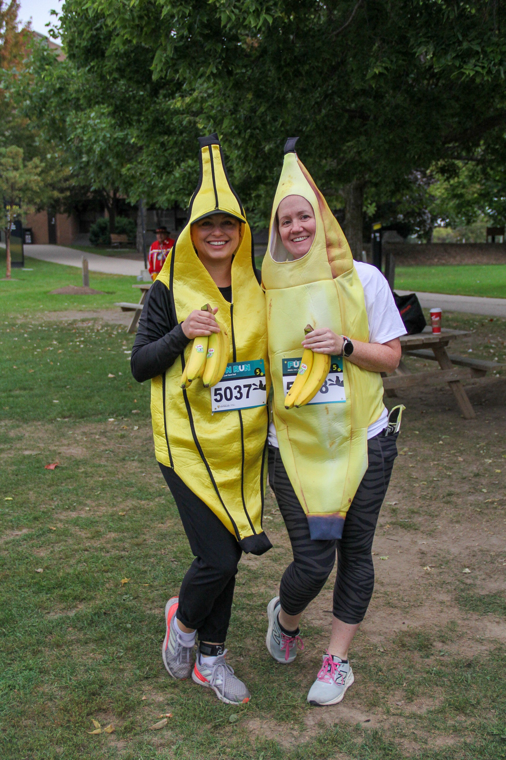 two runners in banana costumes holding bananas