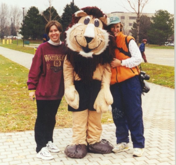 A lion mascot of the Fun Run race standing in the middle with two females