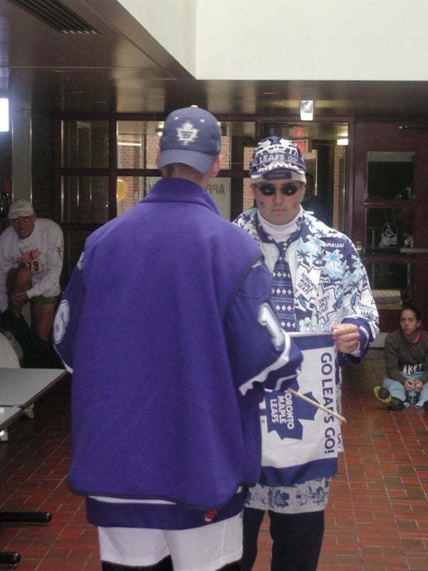 Two male Toronto Maple Leafs fan exchanging a Toronto Maple Leafs flag
