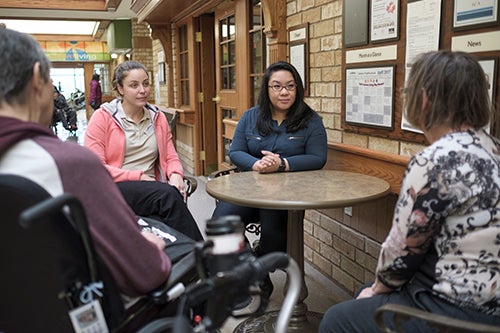Researchers converse with residents at a retirement residence. 