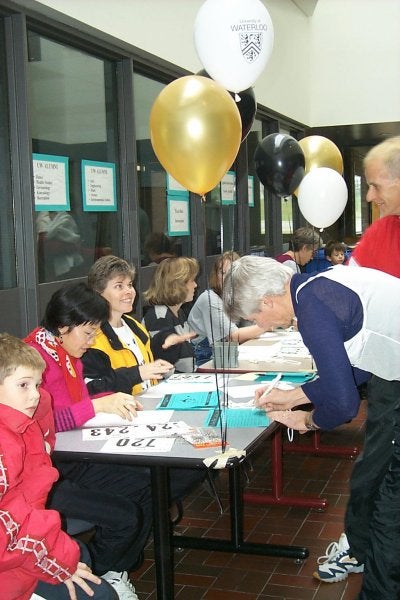 Male and female signing up for the race at the registrar's desk