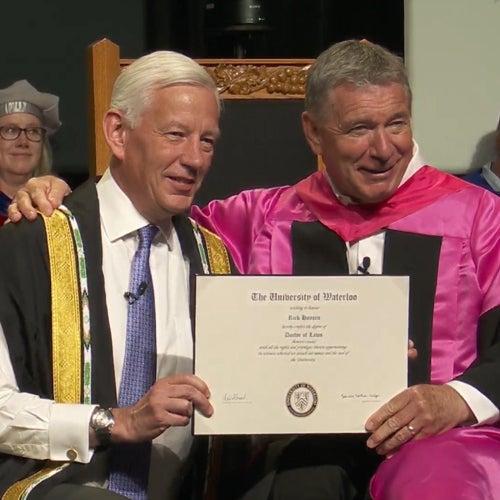 Rick Hansen holding his honorary doctorate degree with Chancellor Dominic Barton