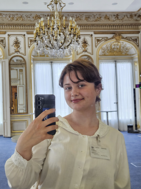 Selfie taken inside the OECD building in a meeting room, with my visitor badge