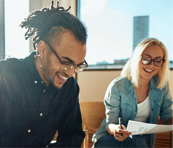 Two students smiling while working