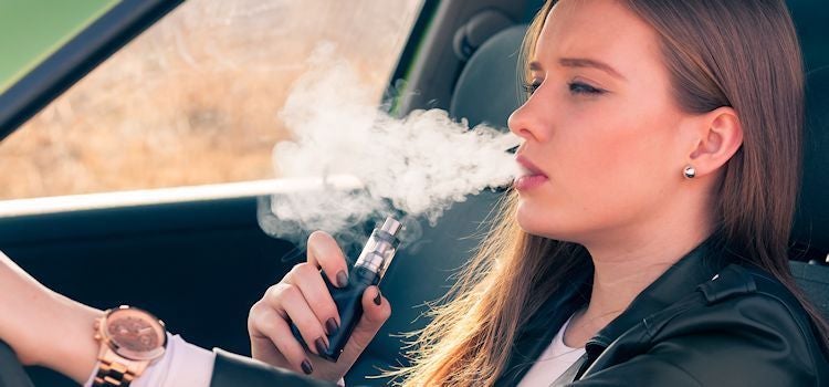 Teenager girl with electronic cigarette in car