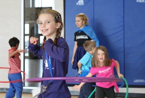 Children hoola hooping in gymnasium.