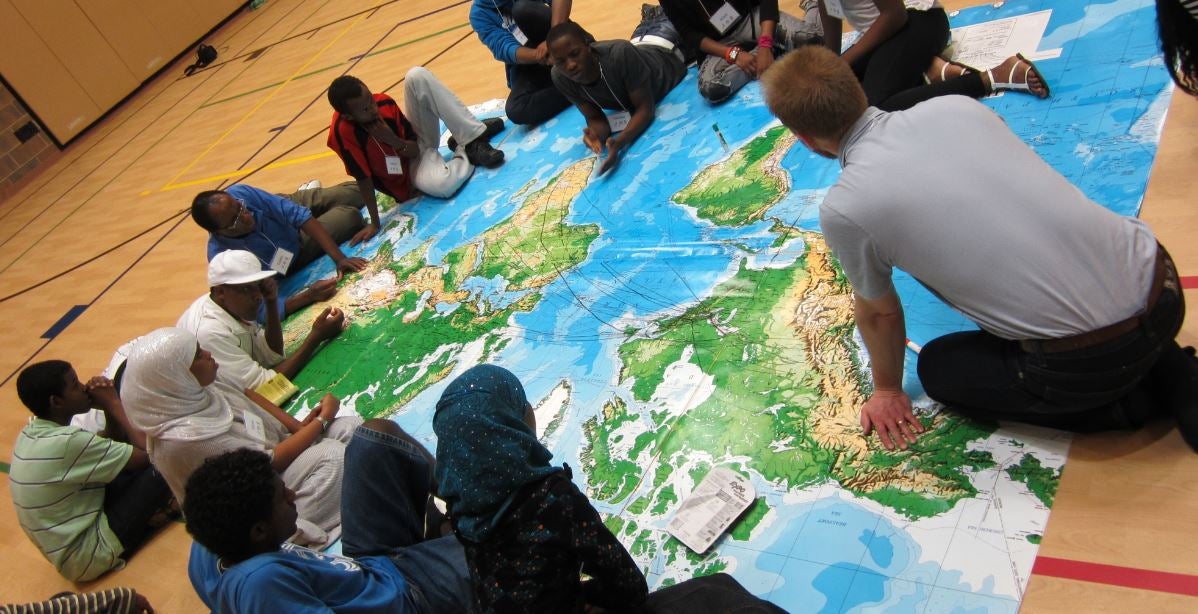 Participants sitting around a large world map