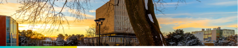 University of Waterloo campus at sunset with snow-covered trees and buildings.