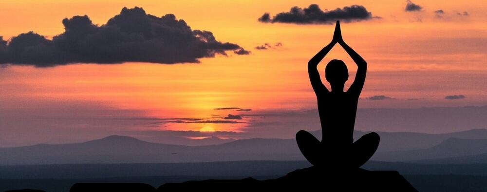 Woman practing yoga at sunset 