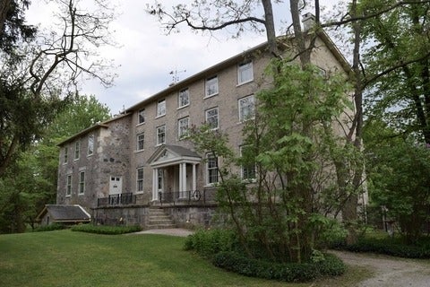 The front exterior of a historic stone building known as the Rockwood Academy