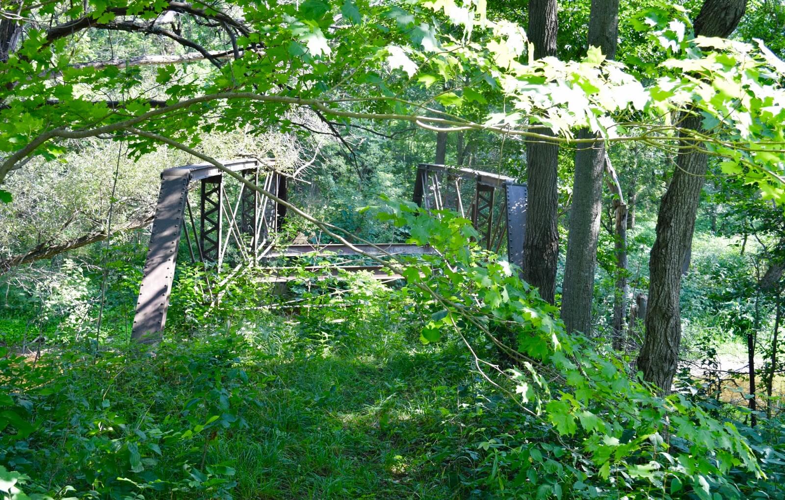 Neglected truss bridge in Sebringville with trees surrounding