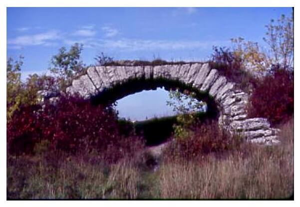 Neglected small stone bridge surrounded by grass