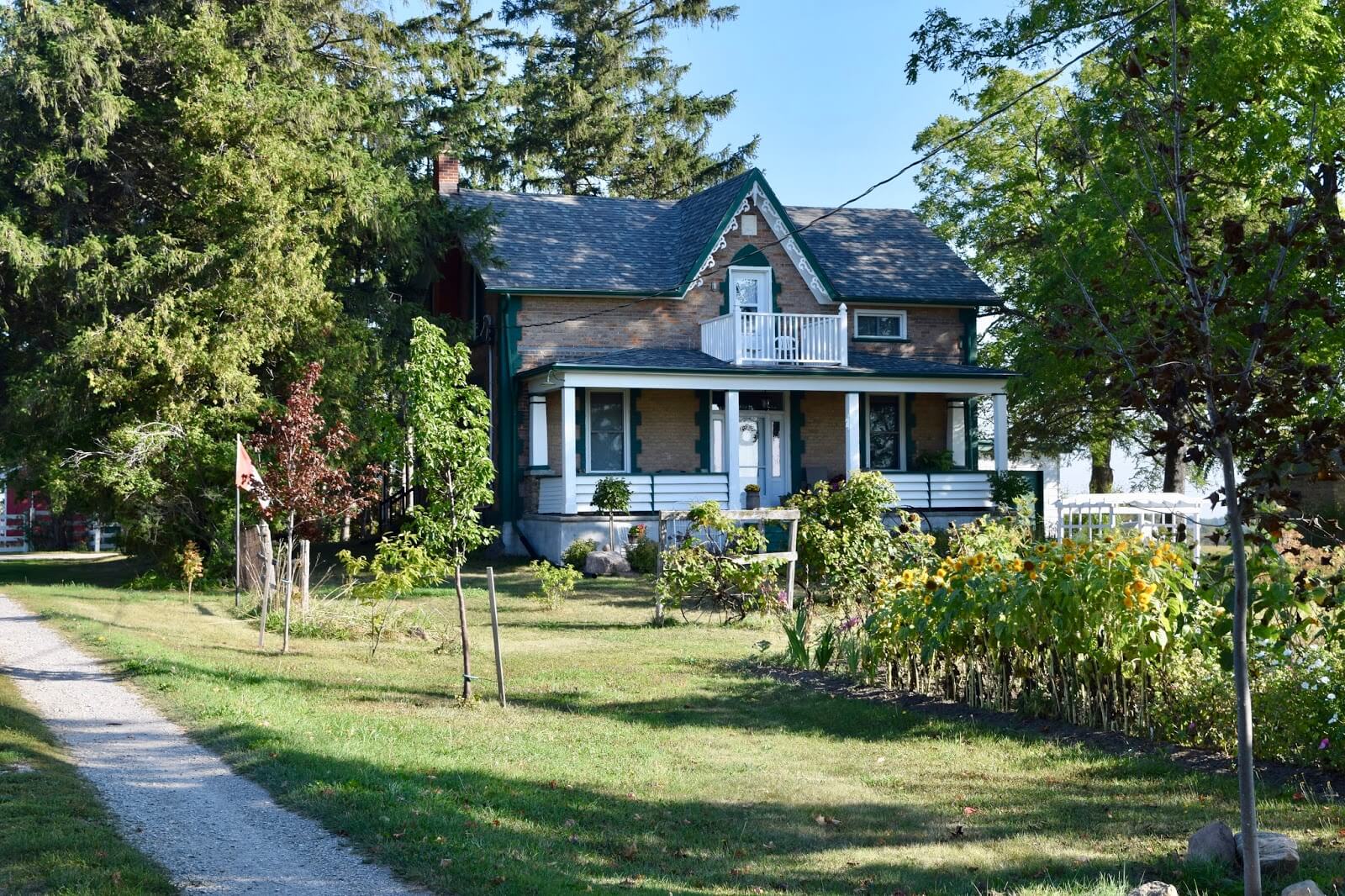 A farmhouse with a garden surrounded by trees in New Hamburg, Ontario