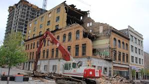 A bulldozer demolishing a building on a city corner