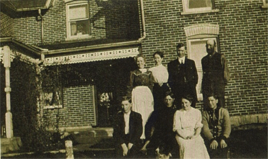 A family photo infront of a farm house in 1910