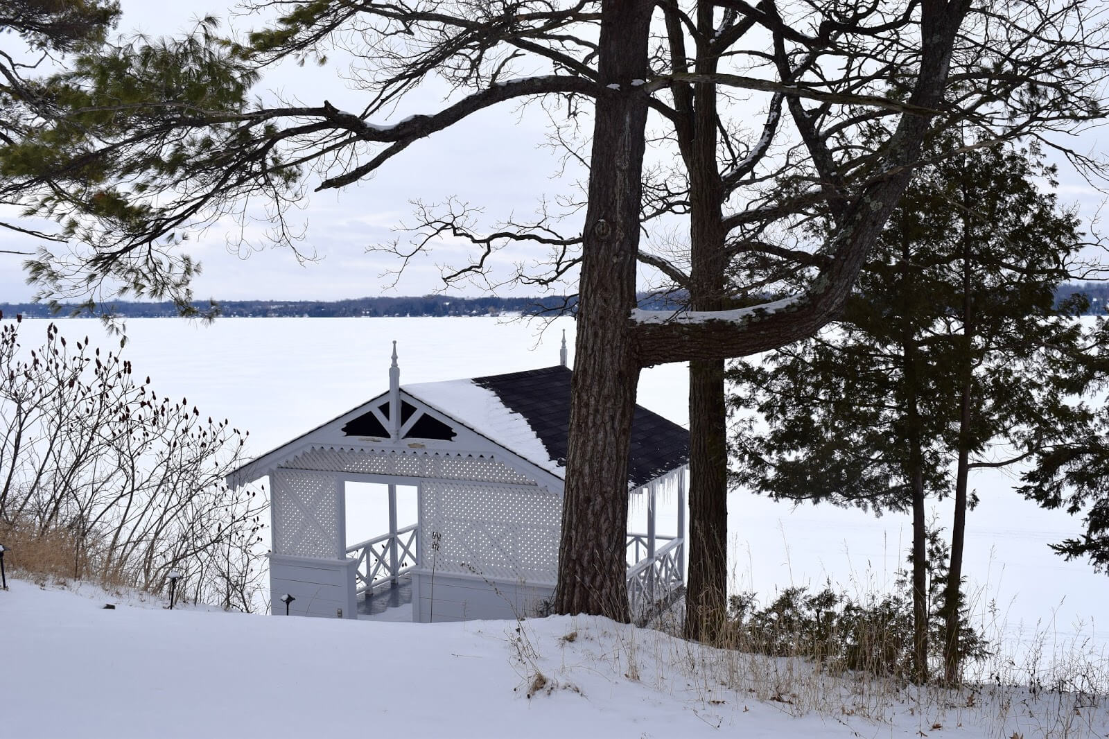 A boathouse on a frozen lake in the winter time