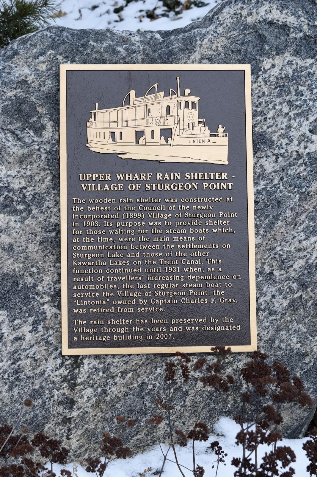 A plaque dedicated to the Upper Wharf Rain Shelter explaining the heritage significance of the building