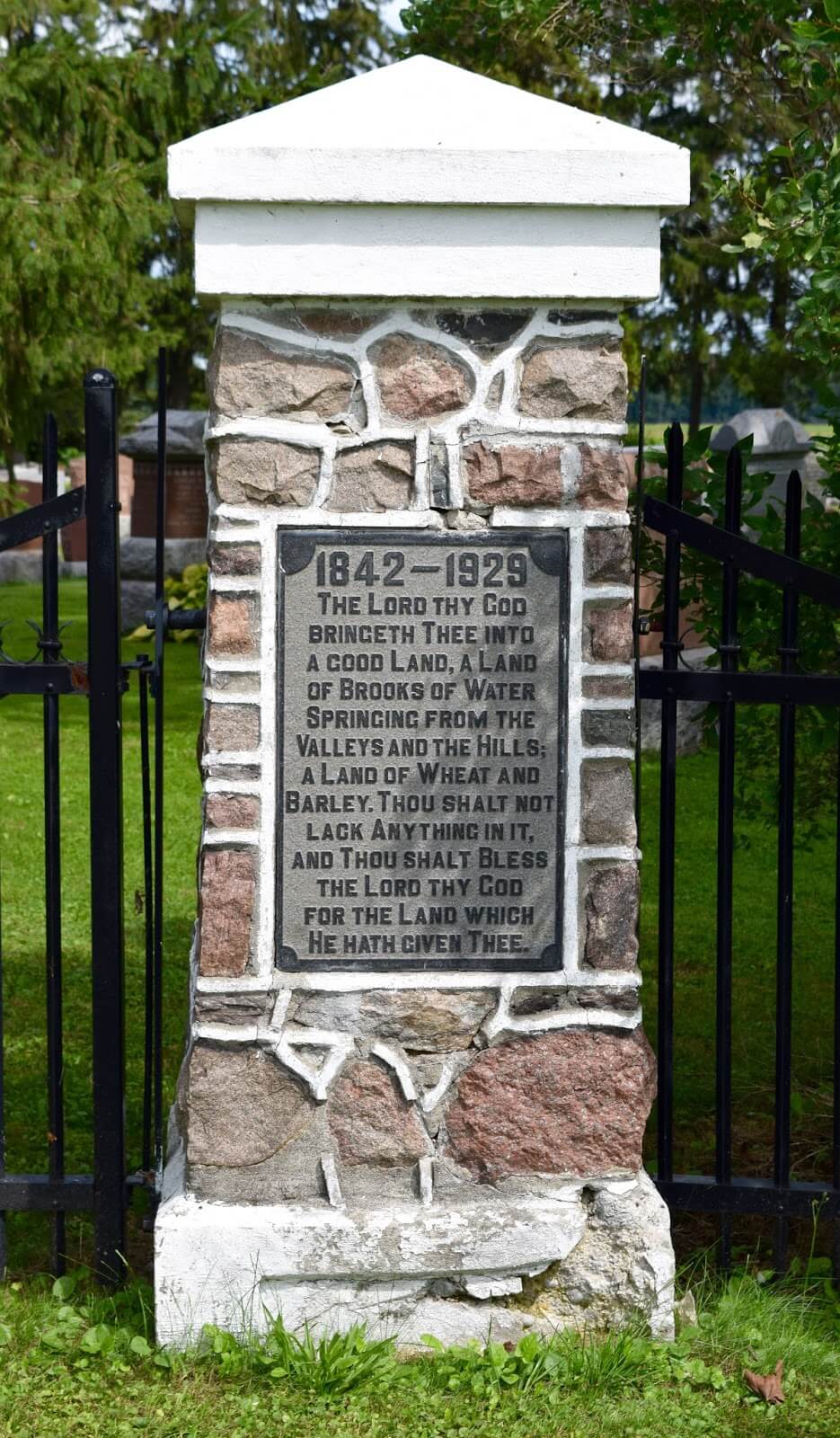 A plaque stating 1842-1929, The Lord thy God bringeth thee into a good land, a land of brooks of water springing from the valleys and the hills; a land of wheat and barley. Thou shalt not lack anything in it, and thou shalt bless the Lord thy God for the land which He hath given thee.