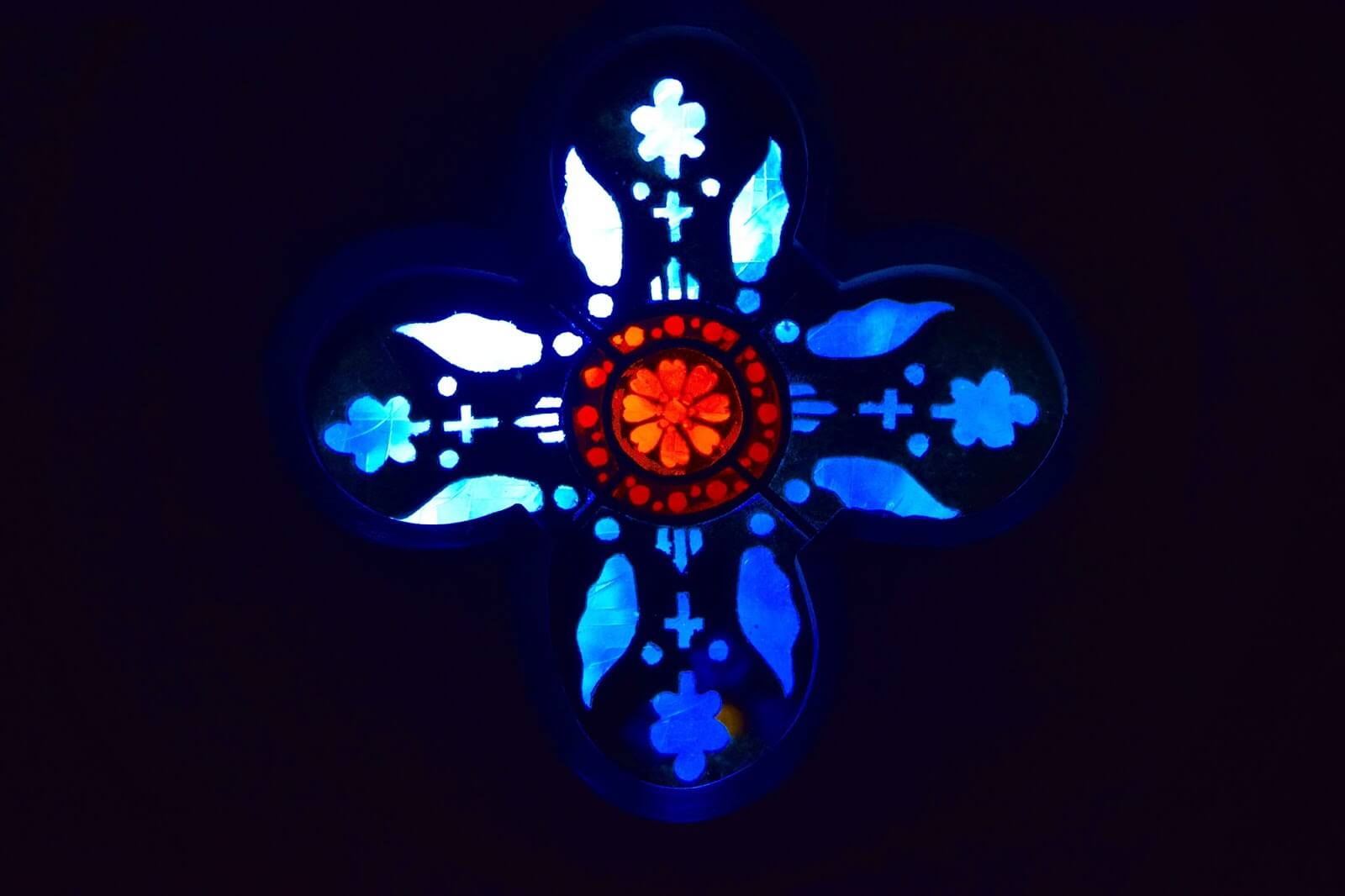 Quatrefoil stained glass with a red core surrounded by blue.