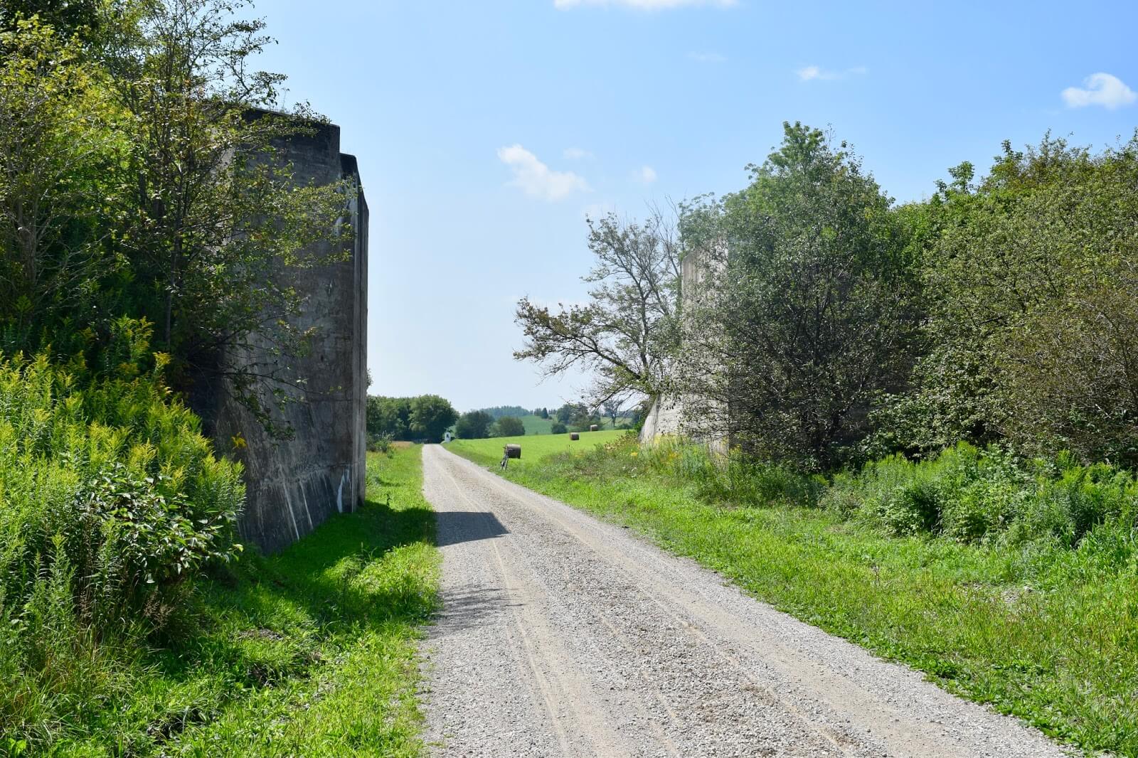 Bridge abutments with a gravel road between them.