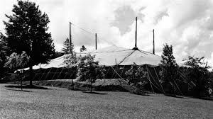 A black and white historic photo of a large tent raised in Queen's Park, Stratford