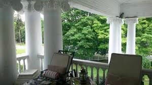 A view from the portico of the columned Stratford White House with patio chairs
