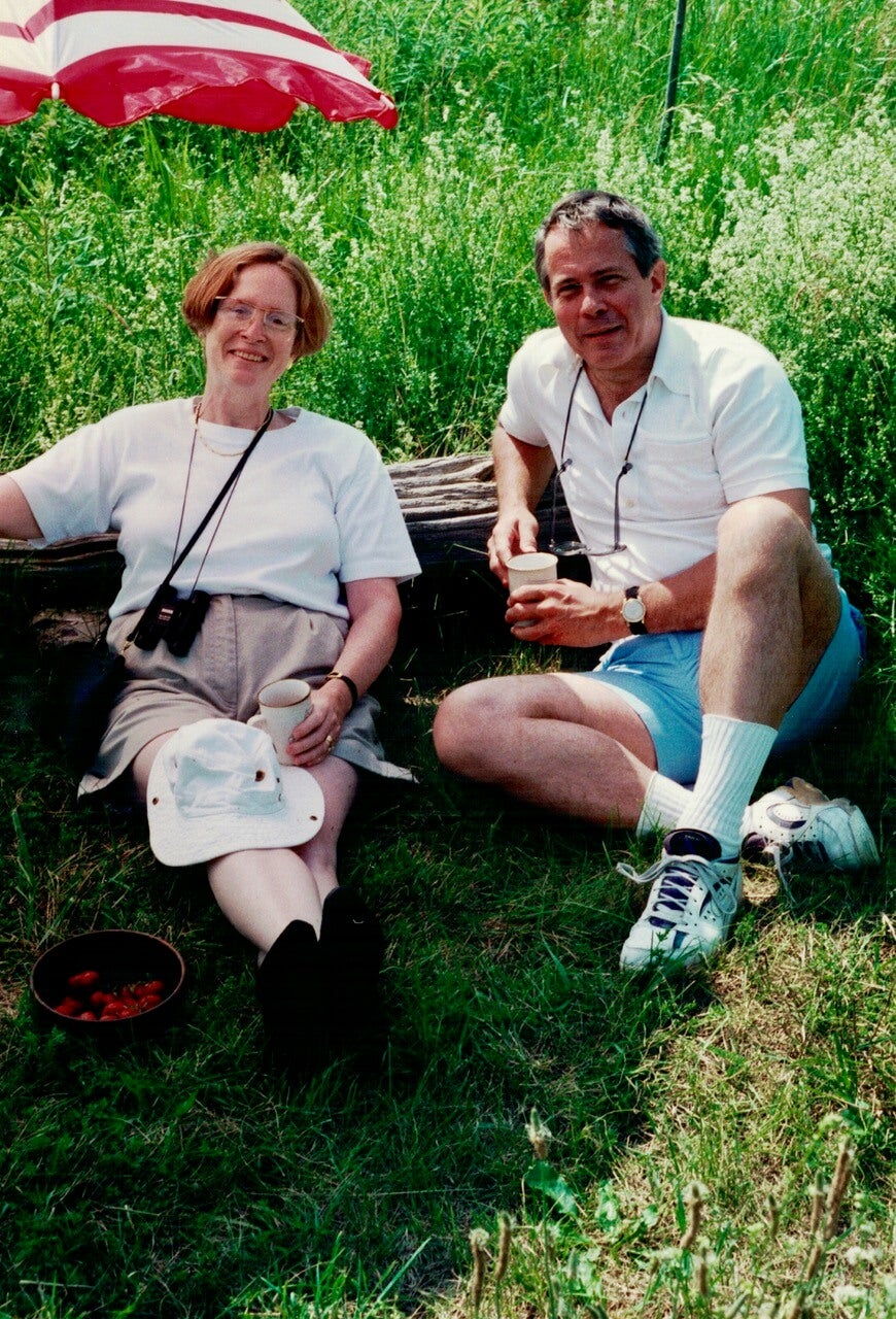 A photograph of Steve Otto with friend Lynne DiStefano, lying in the grass under an umbrella, St. Marys, 1995