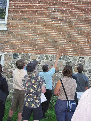 Workshop leader Phillip Grover takes the group outside to examine the finer points of masonry.