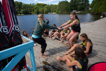 University of Waterloo co-op student demonstrating how to wakeboard to campers at Muskoka Woods