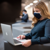 girl sitting at computer wearing mask