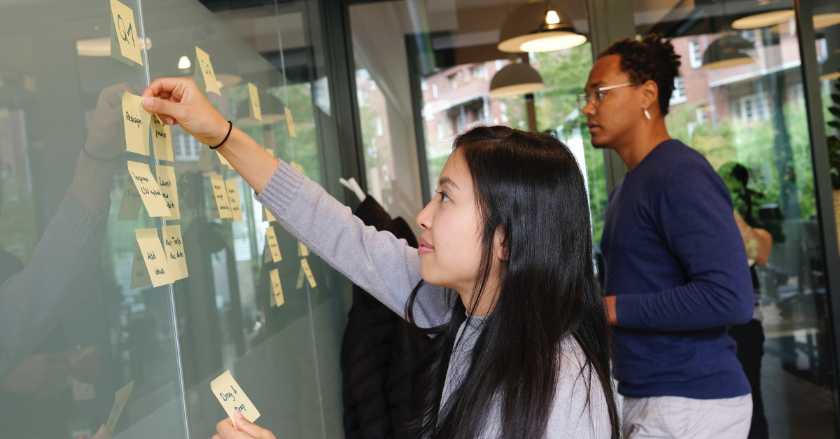 Two co-op students brainstorming new ideas using sticky notes