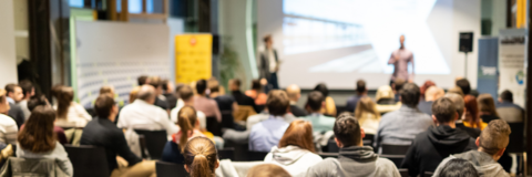 An employer presenting at an Employer Information Session (EIS) in front of a large group of students