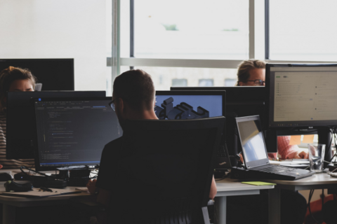 Three students working on cyber security code in the office