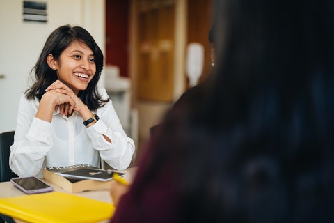 student smiling sitting at table
