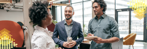 People standing and talking in an office setting