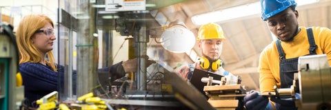 Female student on the left and two male students on the right, working on equipment in industrial engineering setting.