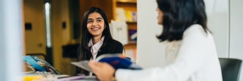 Two co-op students looking at each other, in an interview at the university of Waterloo smiling. 