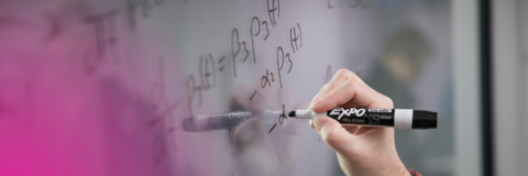 Student solving a calculus equation on a whiteboard