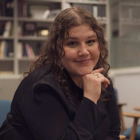 Sarah Larochelle, 2024 Co-op Student of the Year, smiling while seated in a classroom setting with bookshelves in the background.