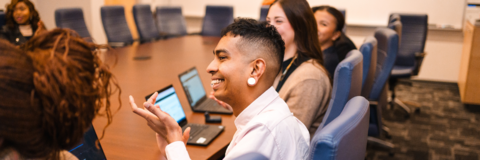 Group of employees in a meeting in a boardroom clapping