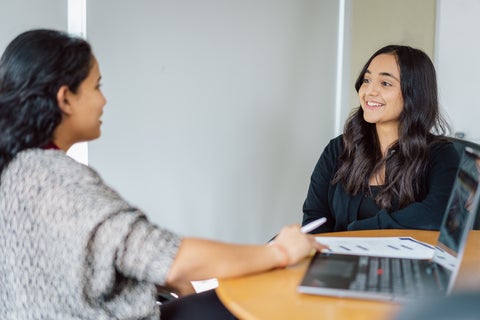 Student and employer chatting, smiling.