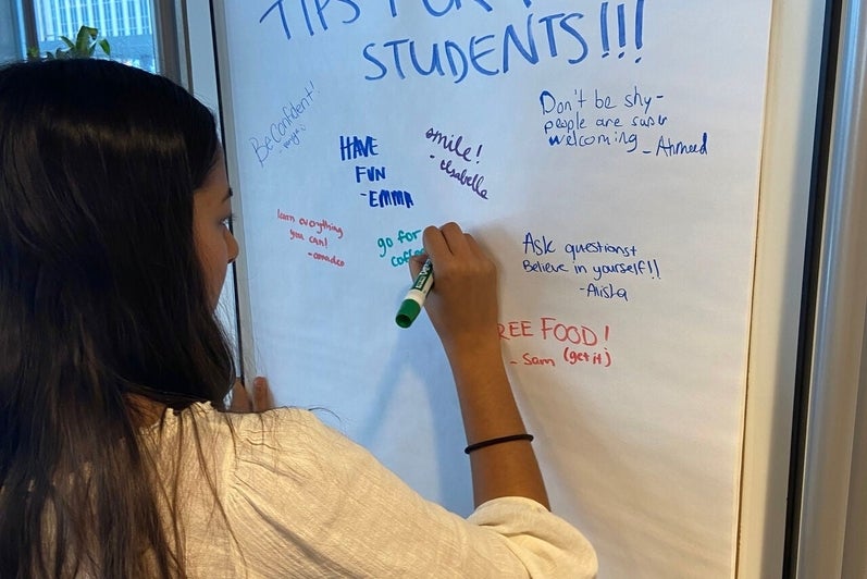 Female co-op student writing tips on big piece of paper