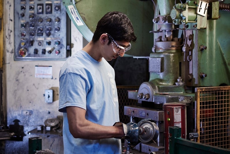 Male University of Waterloo co-op student working on the manufacturing shop floor while on a work term at Nahanni Steel