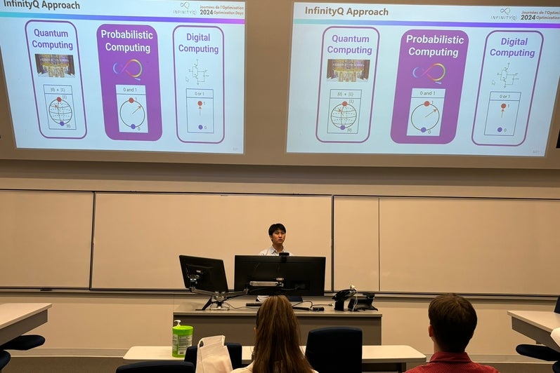 A student sits at a desk presenting a powerpoint presentation
